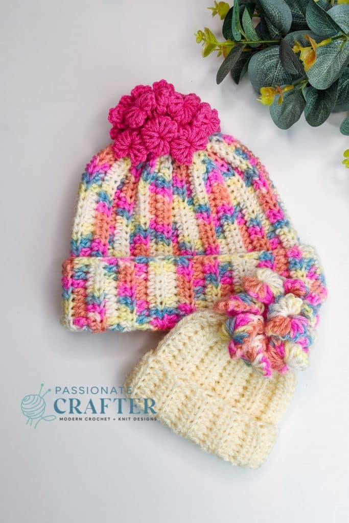 CRochet Valentine beanie with mini crochet heart as pom pom on top. Worked in colorfull pink yarn and pink heart pom pom